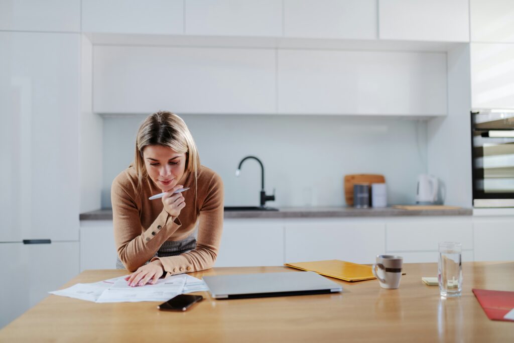 Florida homeowner reviewing insurance declarations page at kitchen table before renewal